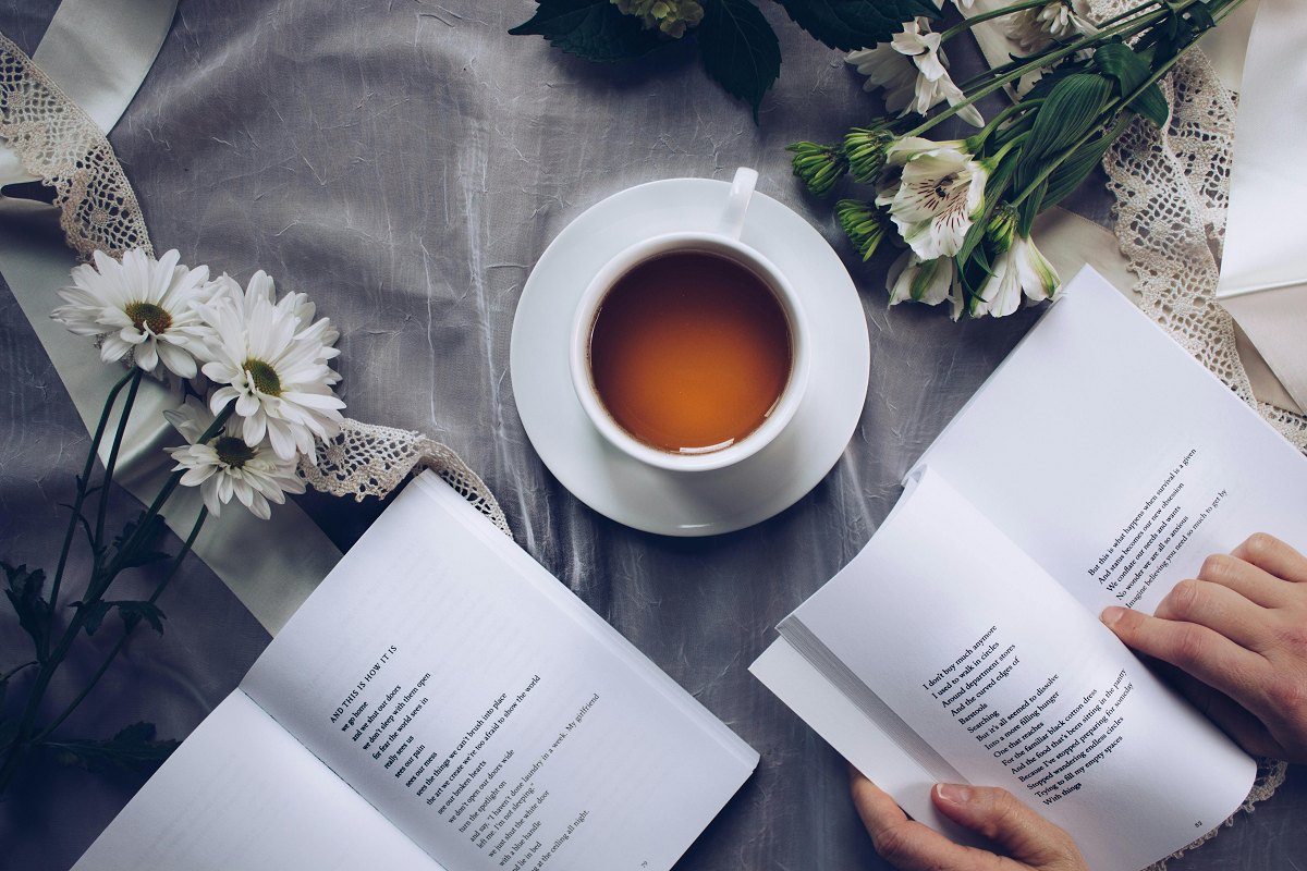 caregiver resting with a cup of coffee and reading a book